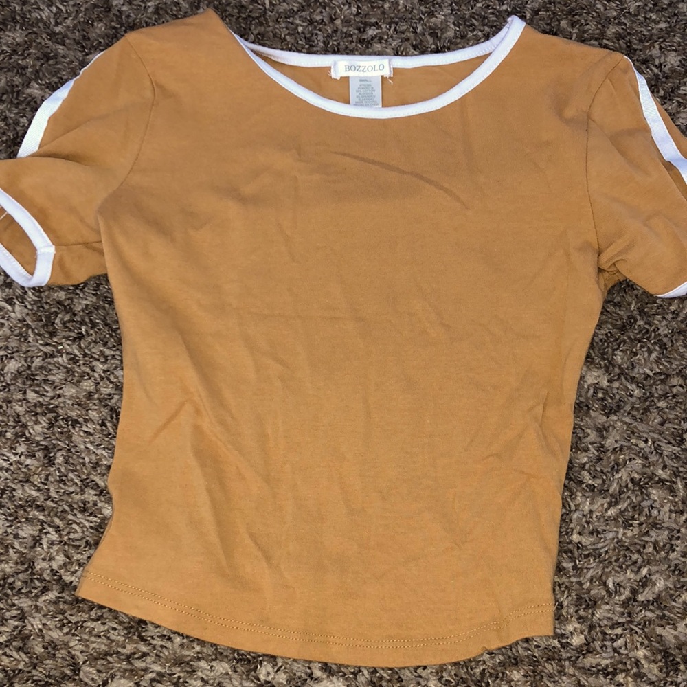 A stylist tan color crop top with white on sleeves and neck line